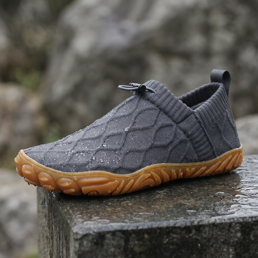 Grey StrideFlex shoe on a wet stone ledge
